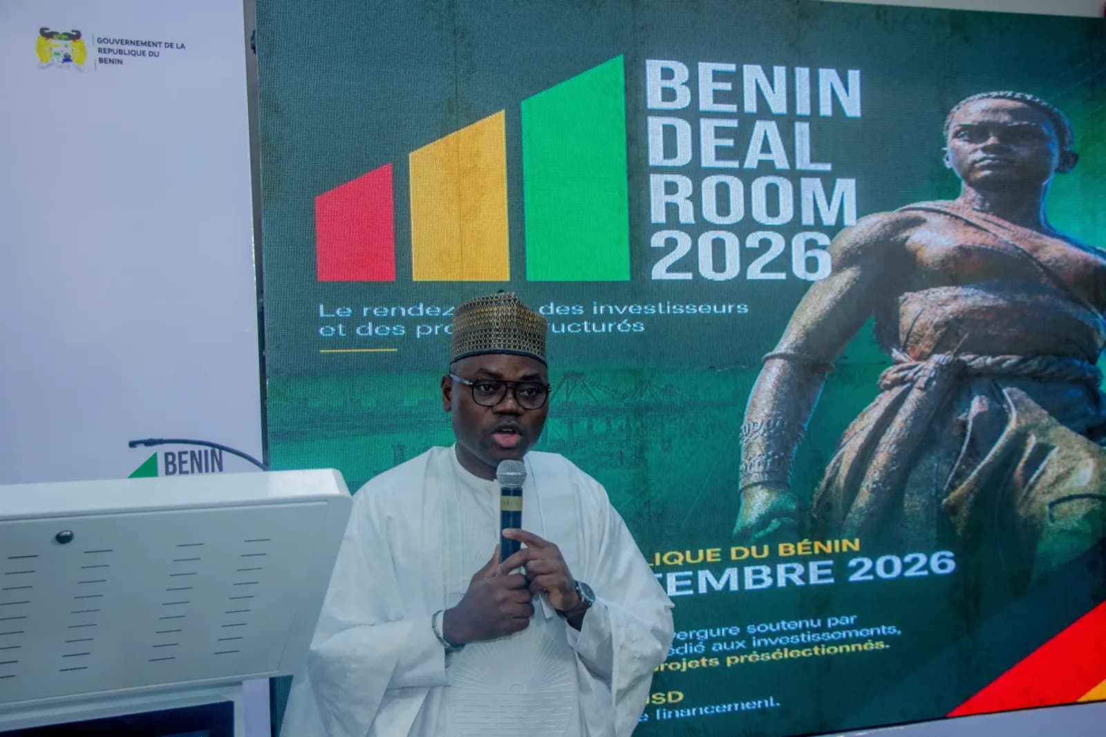 A speaker at the Benin Deal Room 2026 backdrop